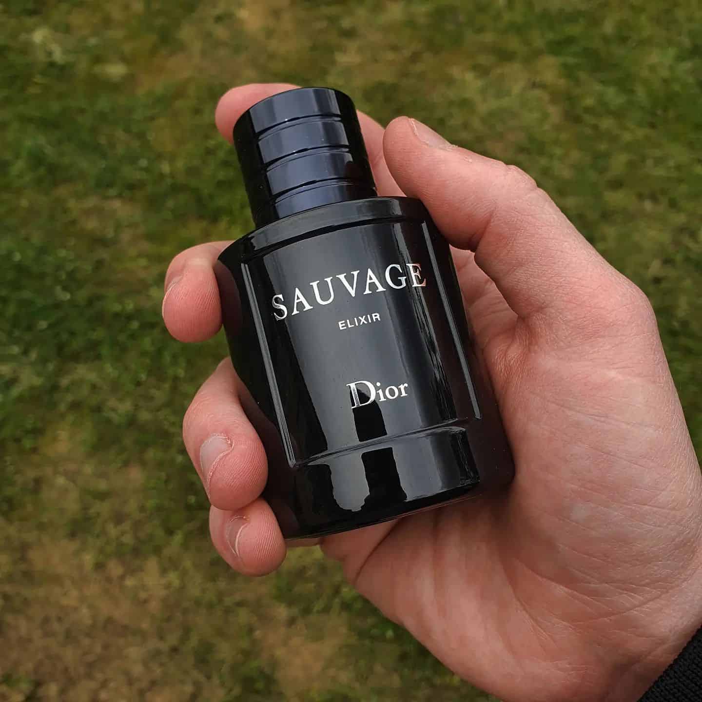 holding a bottle of Sauvage Diorr
