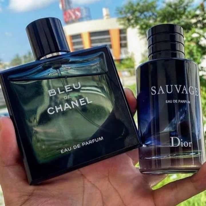 holding a bottle of Blue de Chanel and Dior Sauvage