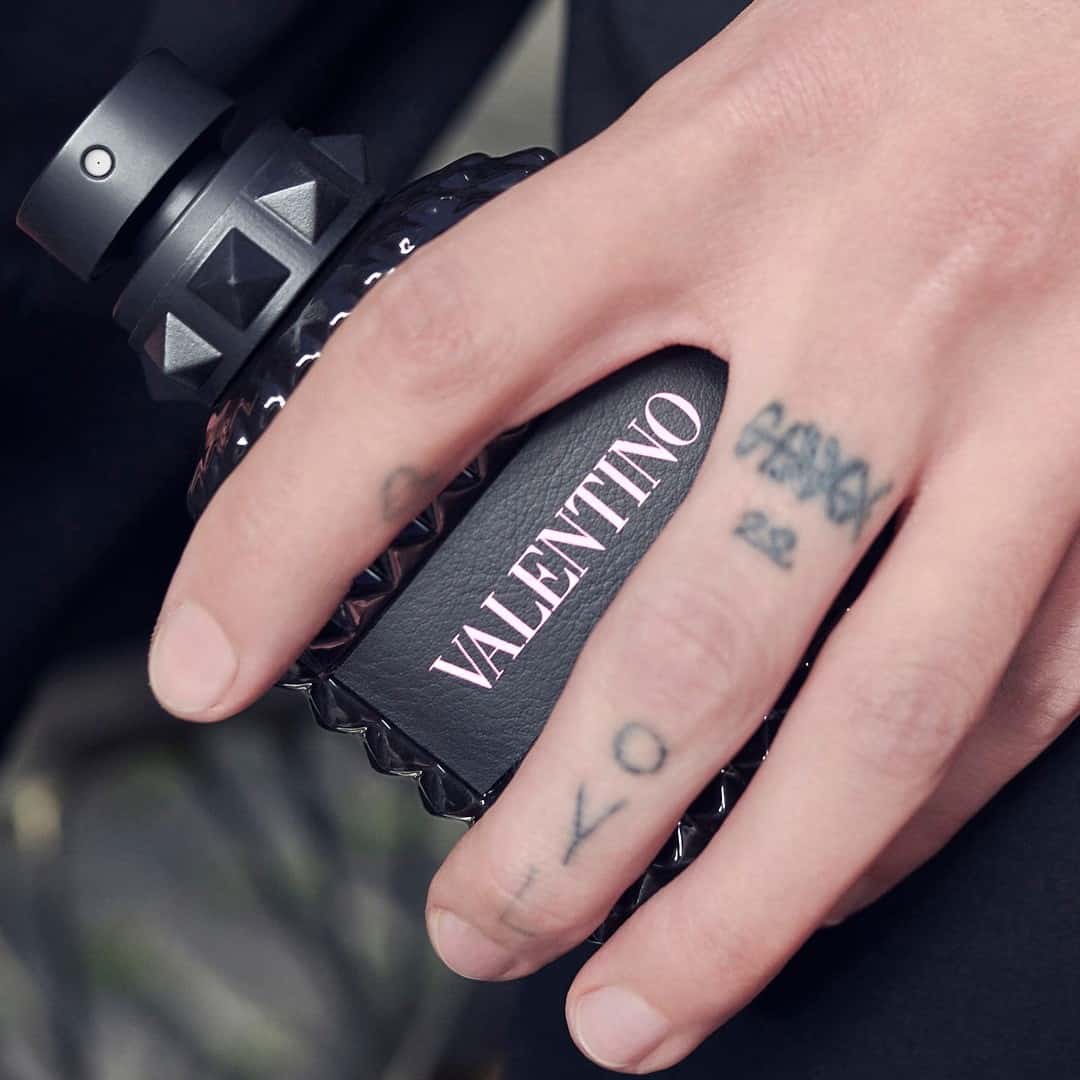 holding a bottle of valentin of ragrance