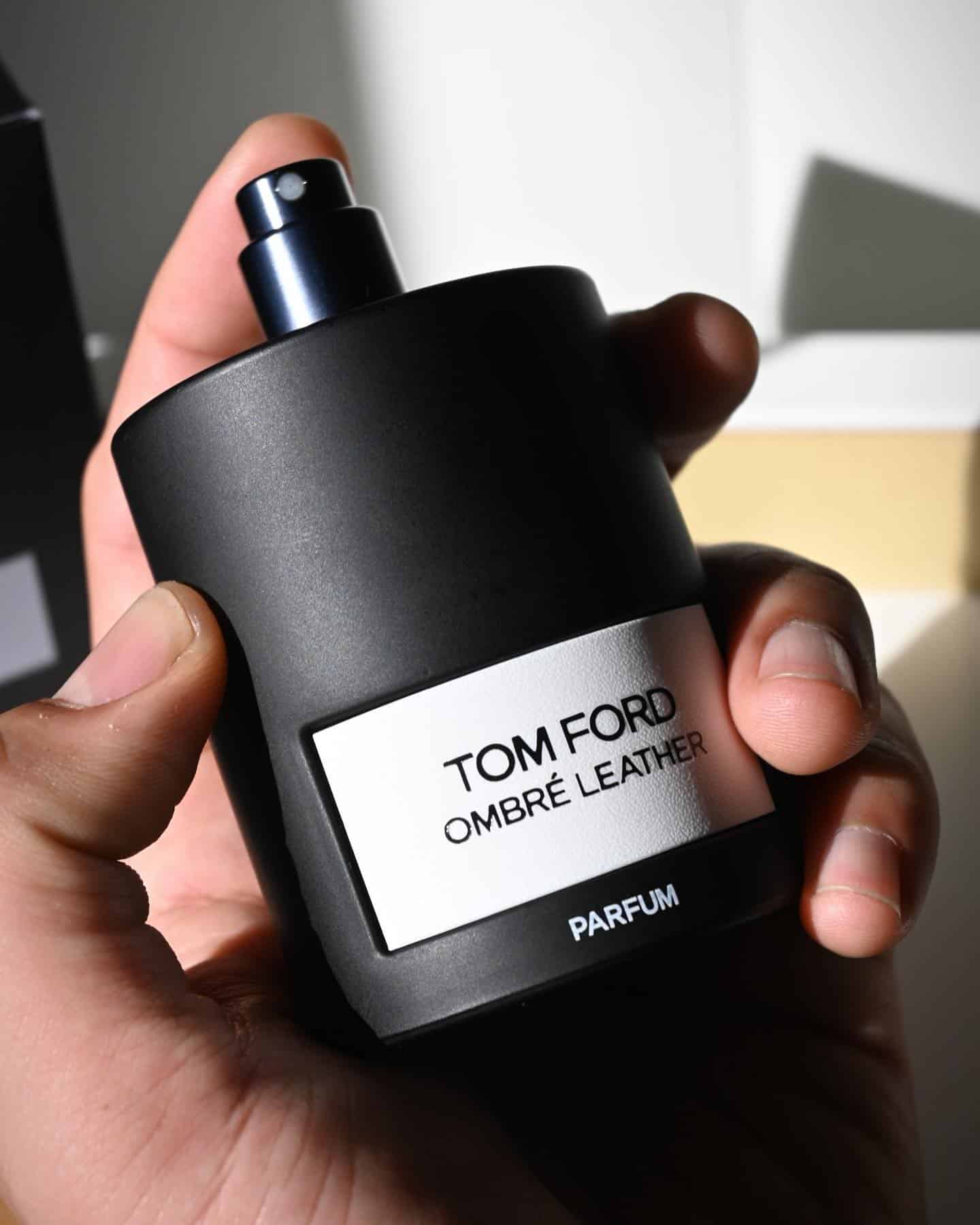 holding a bootle of Tom Ford Ombre Leather