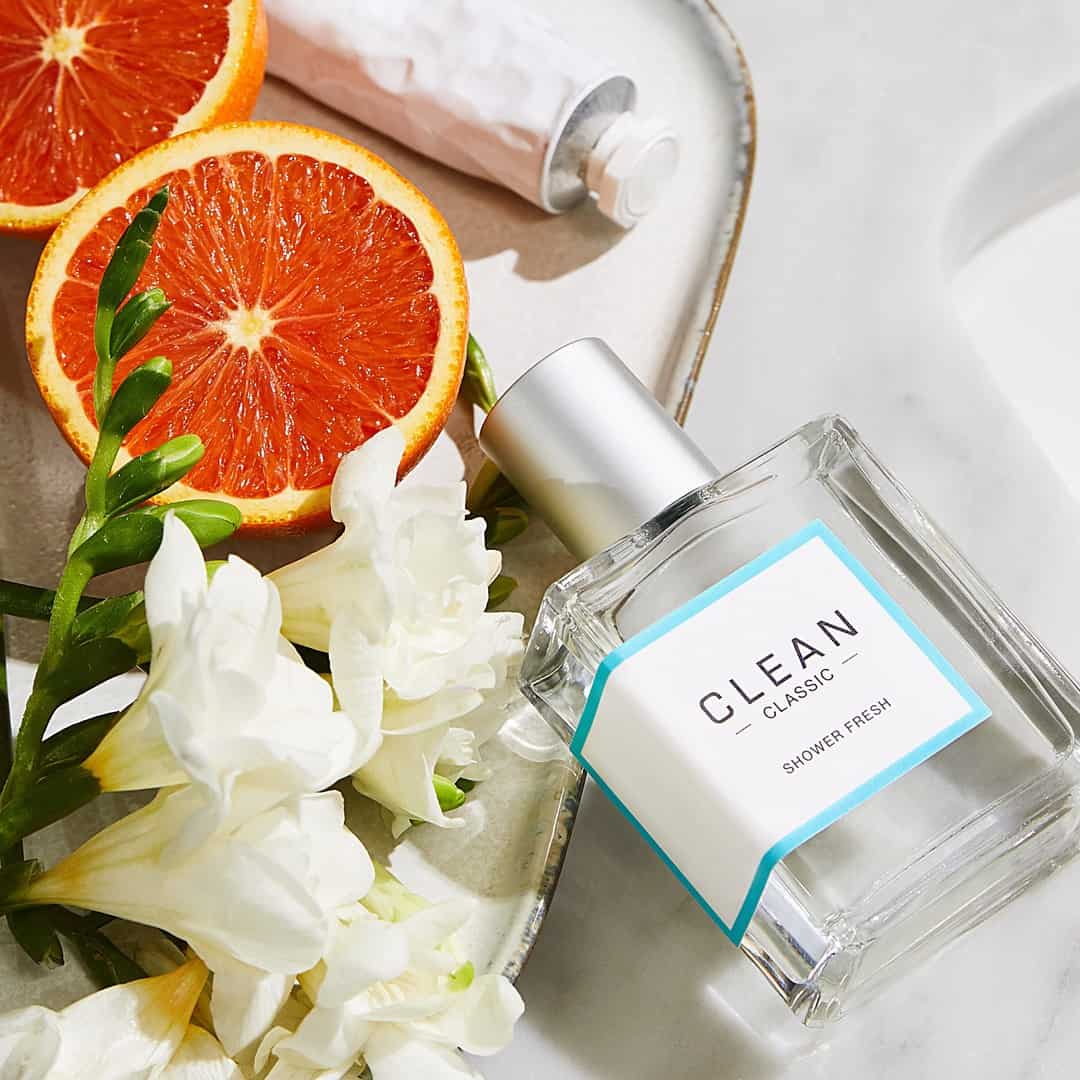 a bottle of clean shower fresh with citrus and flowers on the side