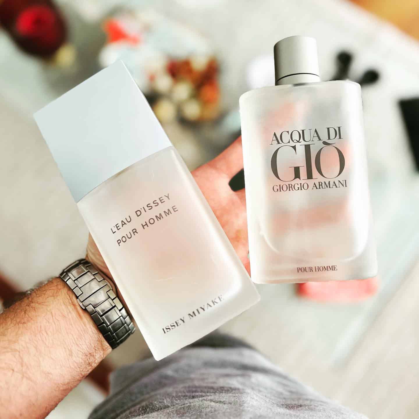 holding two different kind of pour homme fragrance