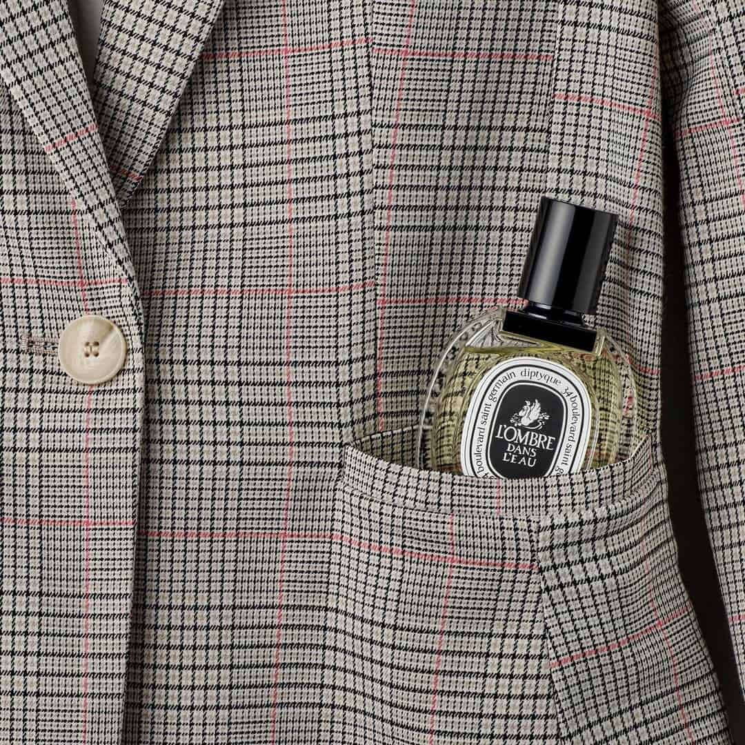 a bottle of L' Ombre Dans L' Eau by Diptyque inside a pocket