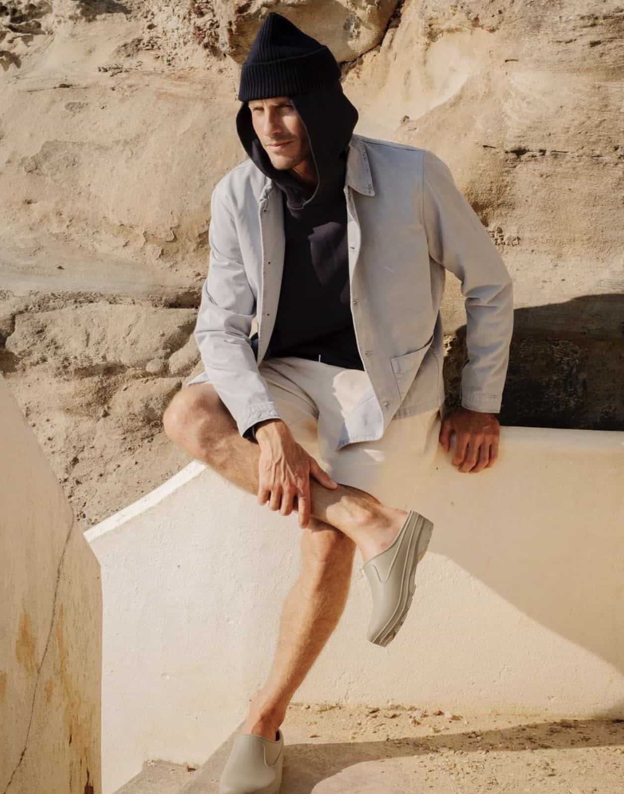 Man wearing tan shirt jacket and dark hoodie and a beanie