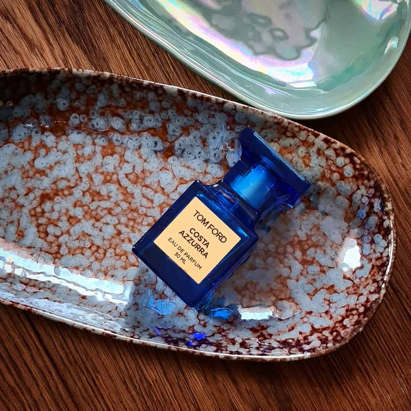 a bottle of tom ford costa azzura acqua in a plate
