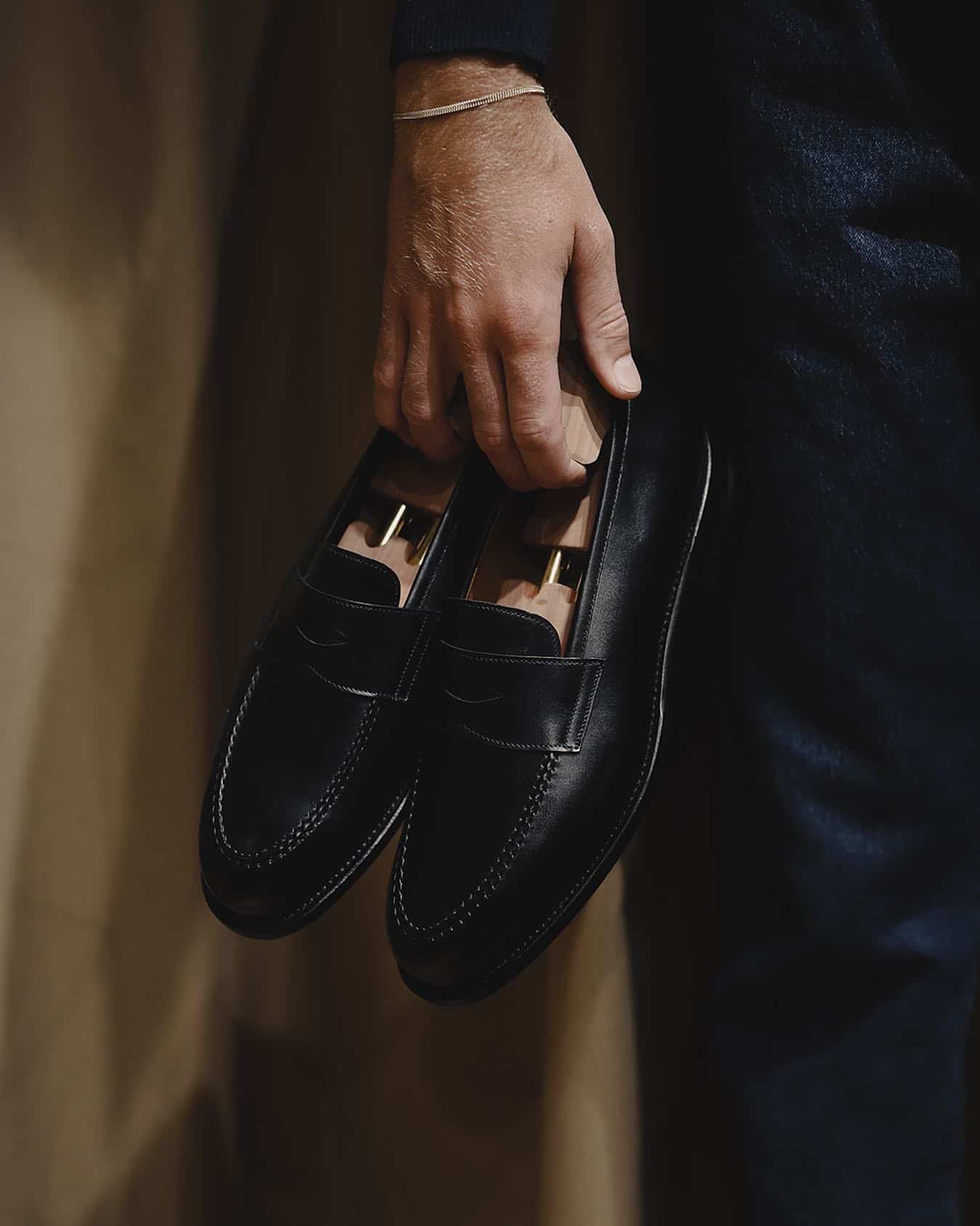 man carrying a pair of loafers