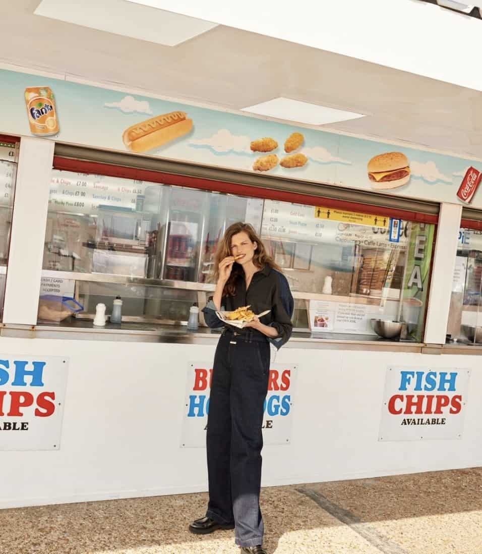 women standing by a food stand, eating