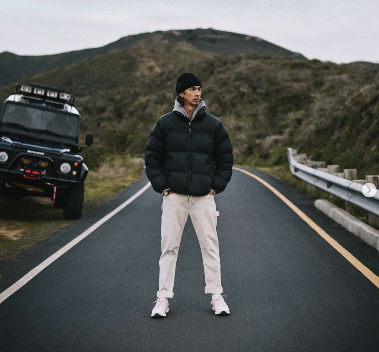 man standing in the middle of the road with a truck off to the side