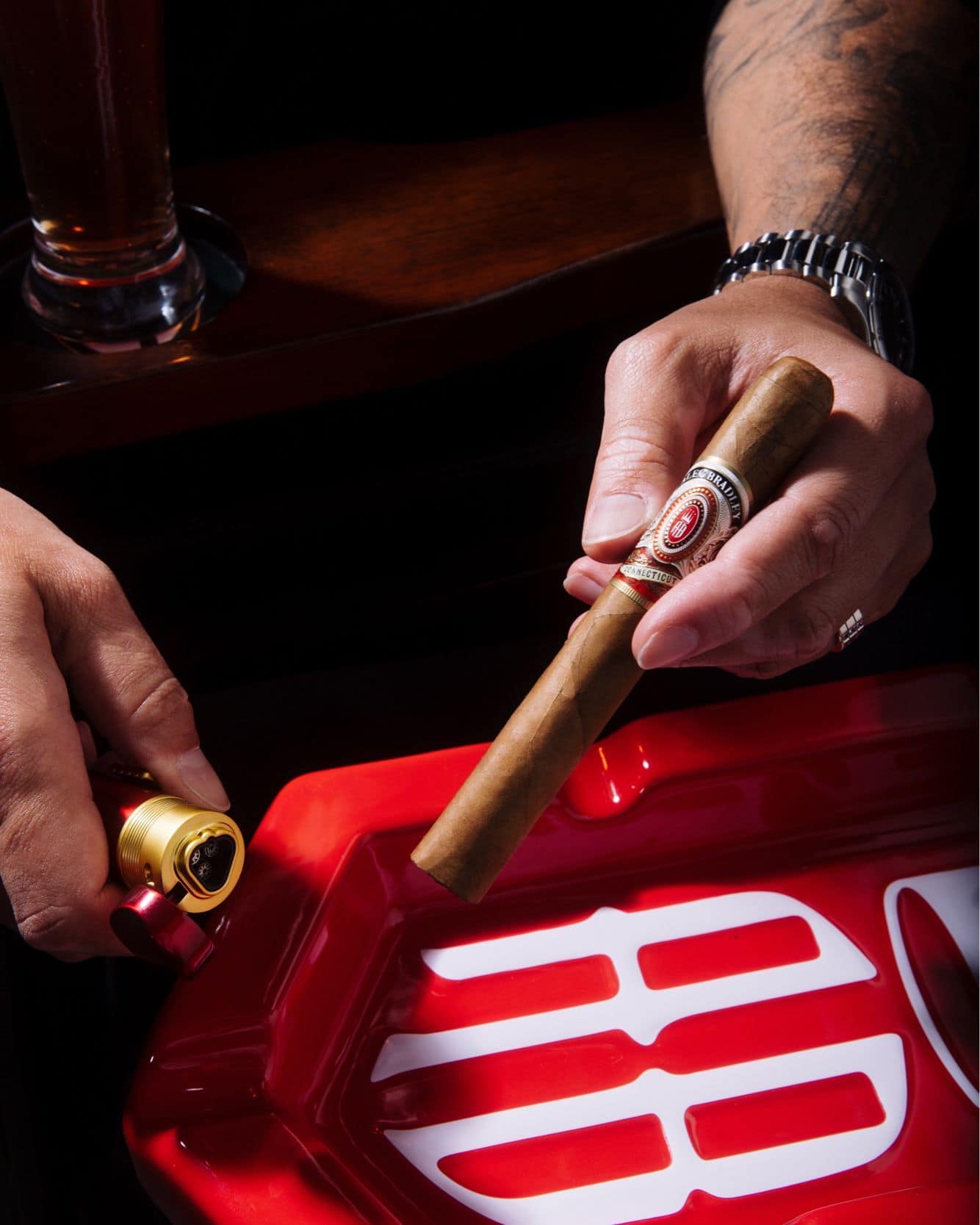 man holding a cigar and a torch lighter