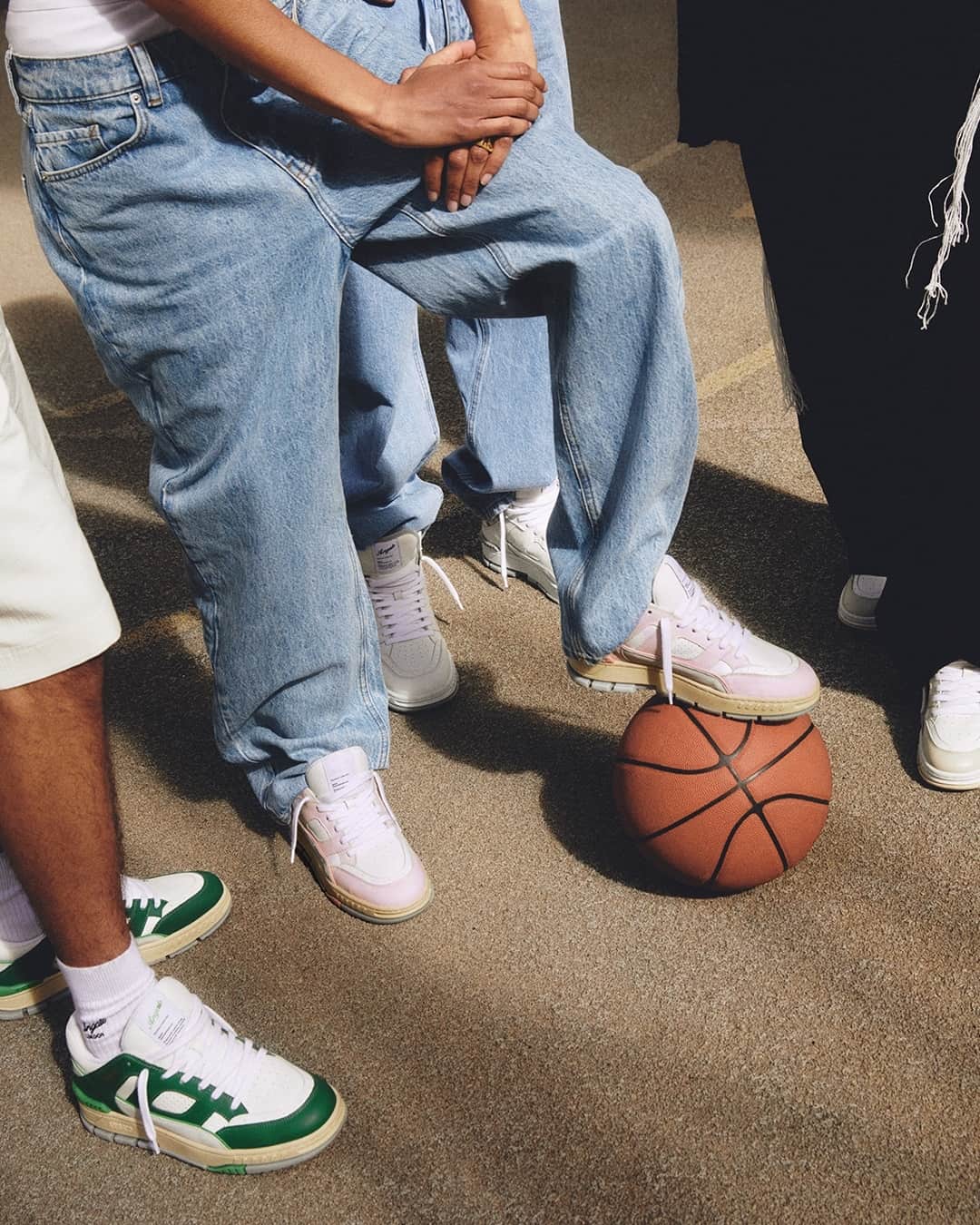 man in baggy jeans stepping on a basketball