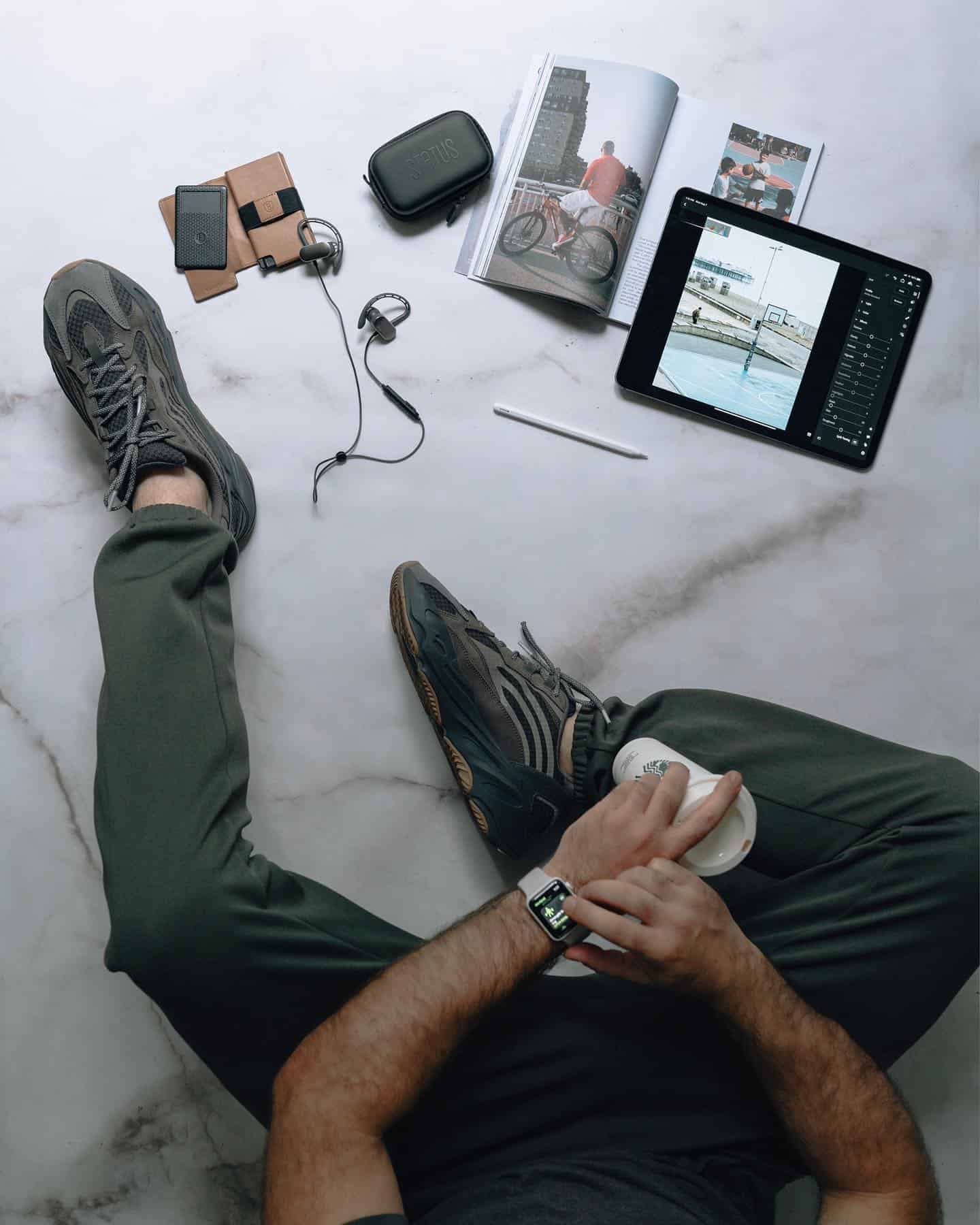 man sitting on the floor with his gadgets