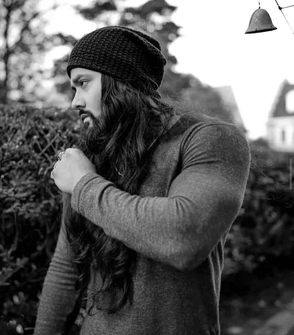 man in a beanie with long wavy hair