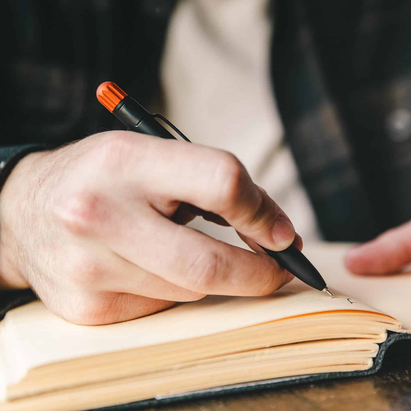 man writing on his journal