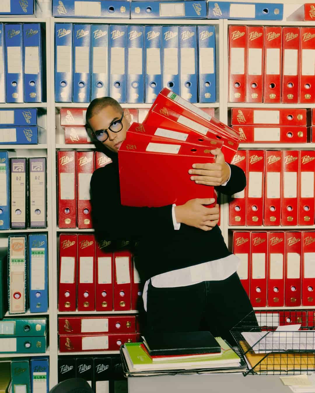 man carrying a stack of records
