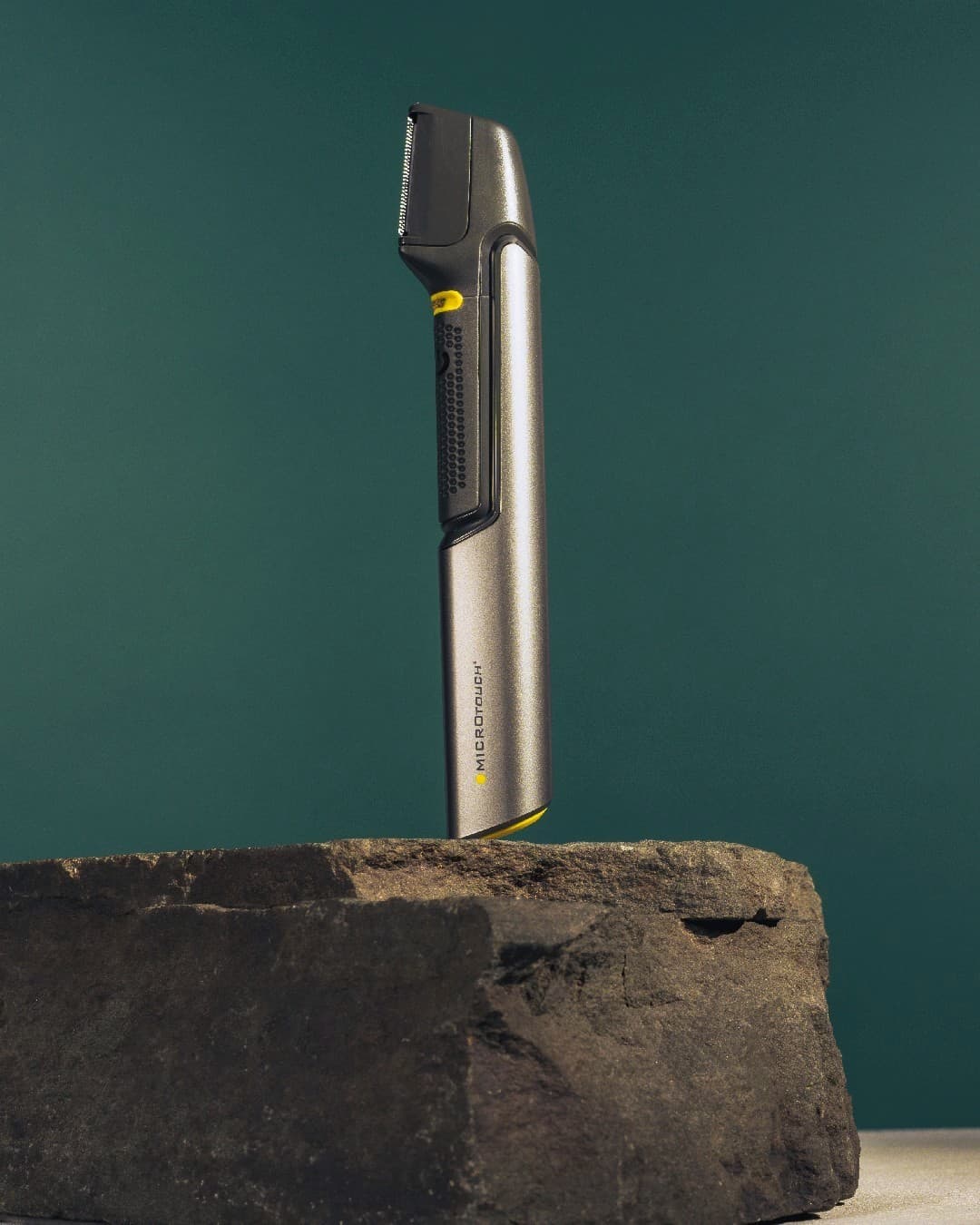 a micro touch groom trimmer standing on a rock