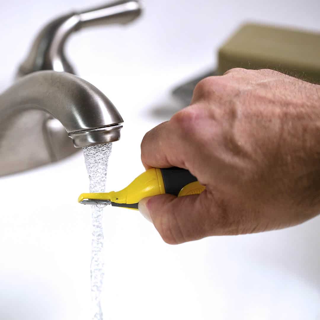 man washing the tip of a trimmer