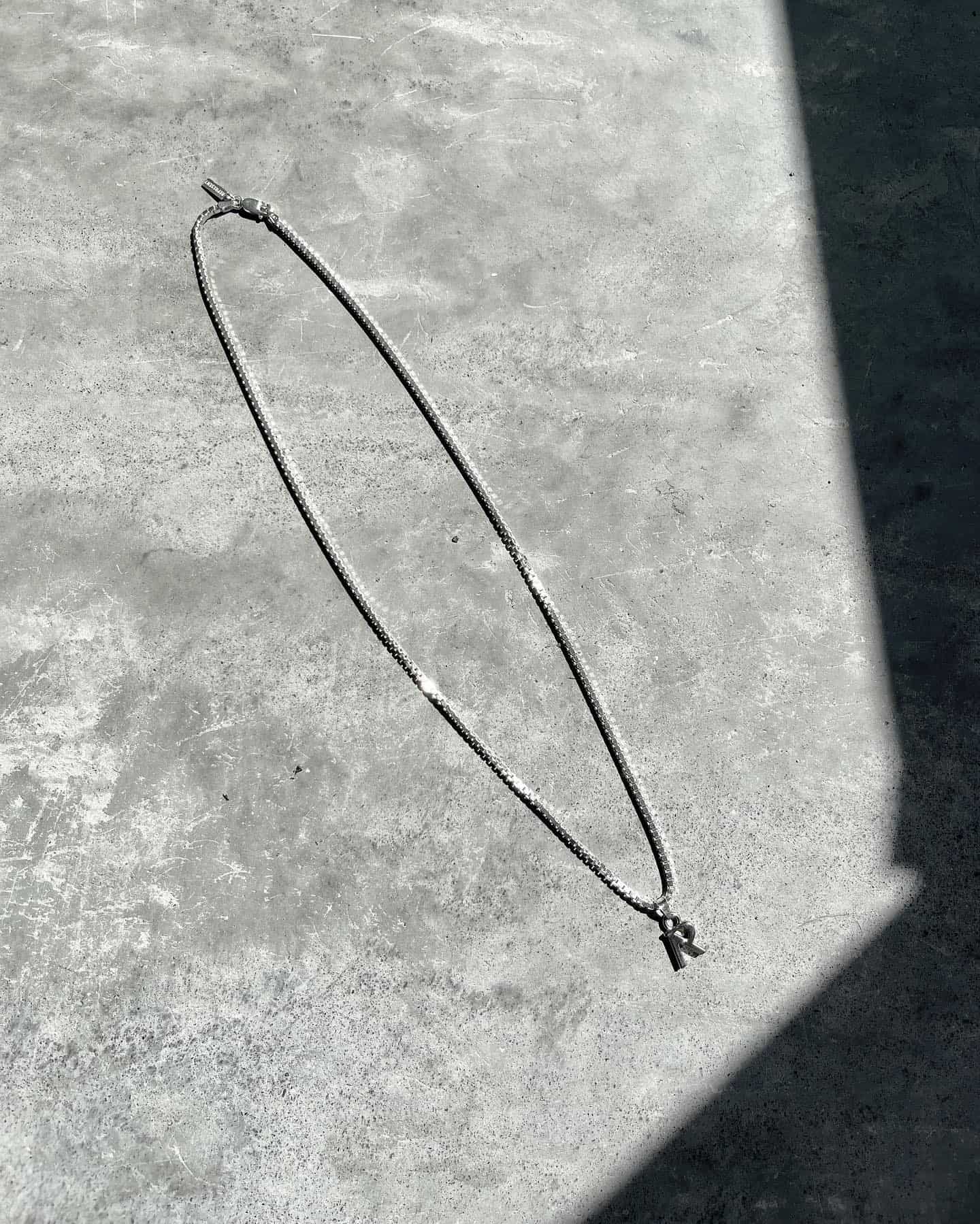 a silver chain necklace on the ground