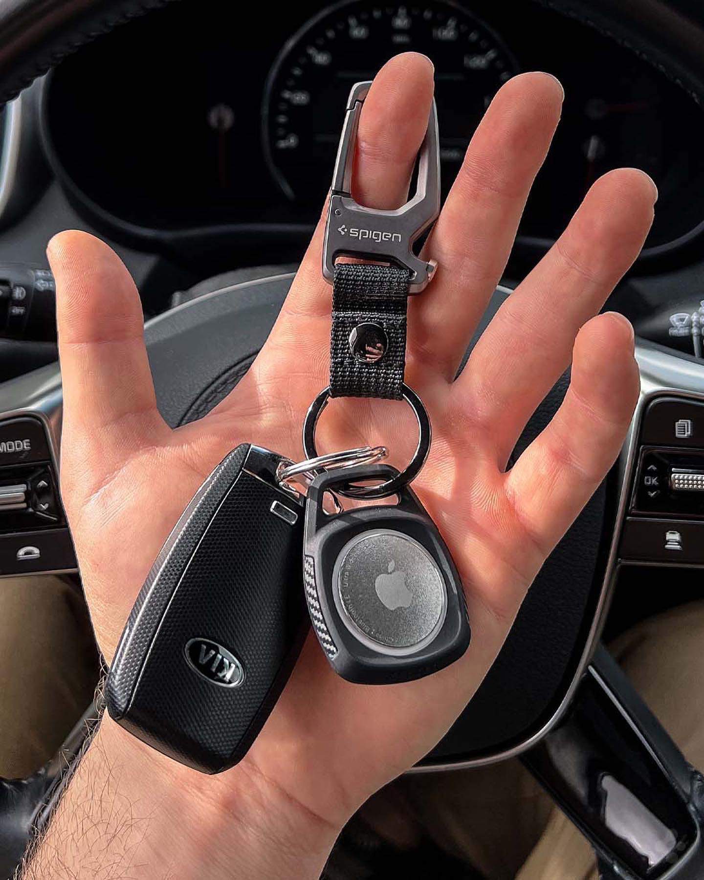 holding a spigen key clip with car keys and an air tag