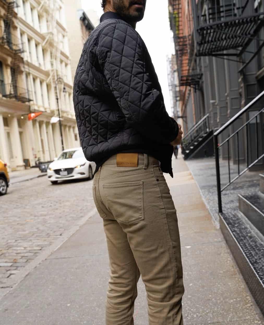 man wearing Mott & Bow Jeans looking over his shoulder on a city street