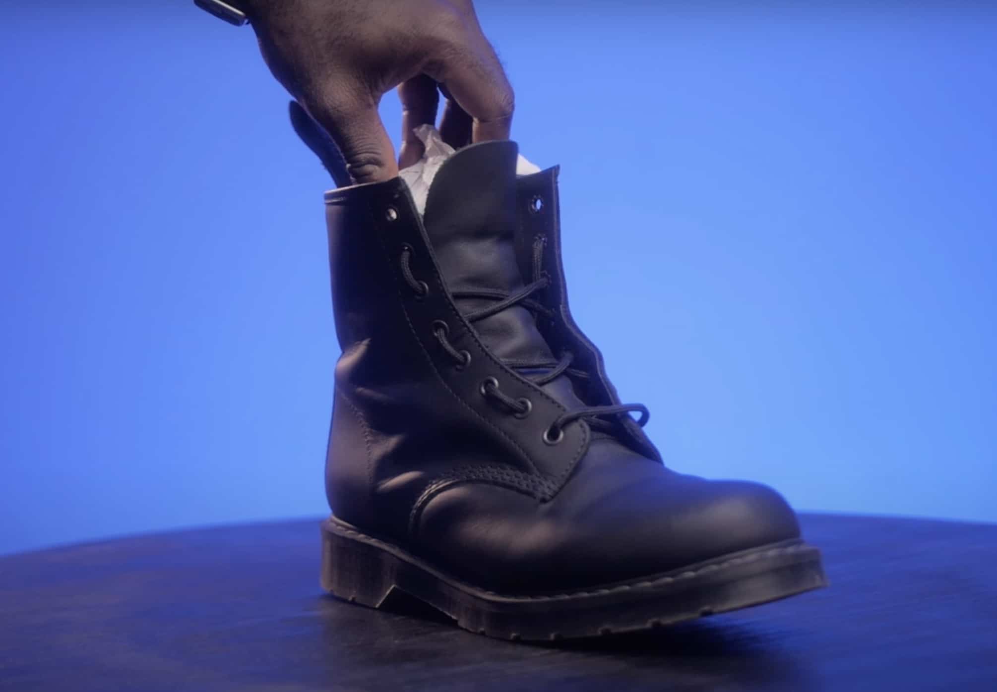 Stuffing a Dr Martens boot with newspaper