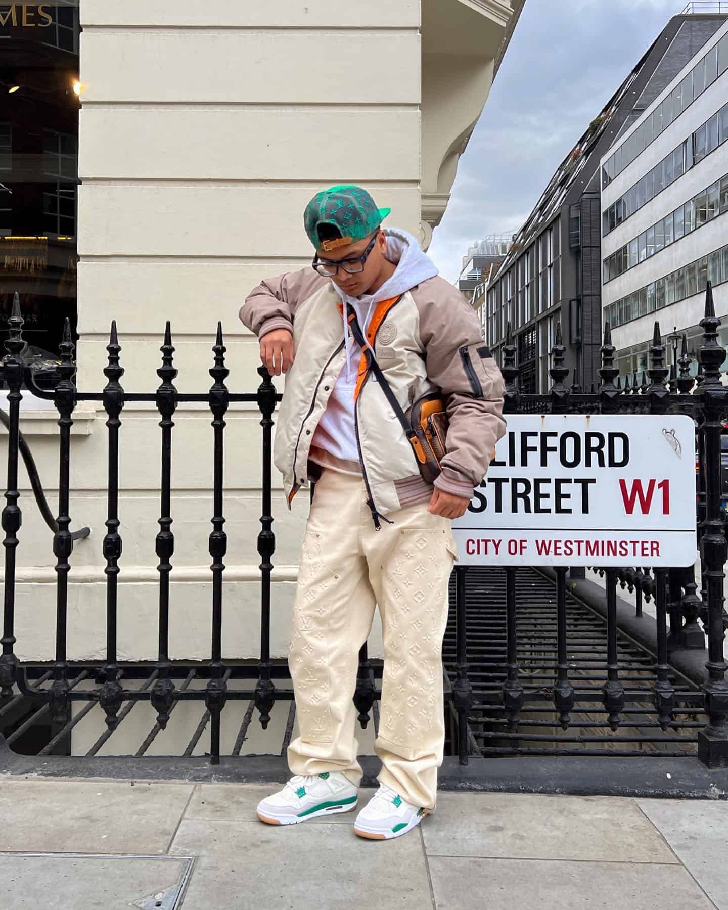 man leaning on a metal fence