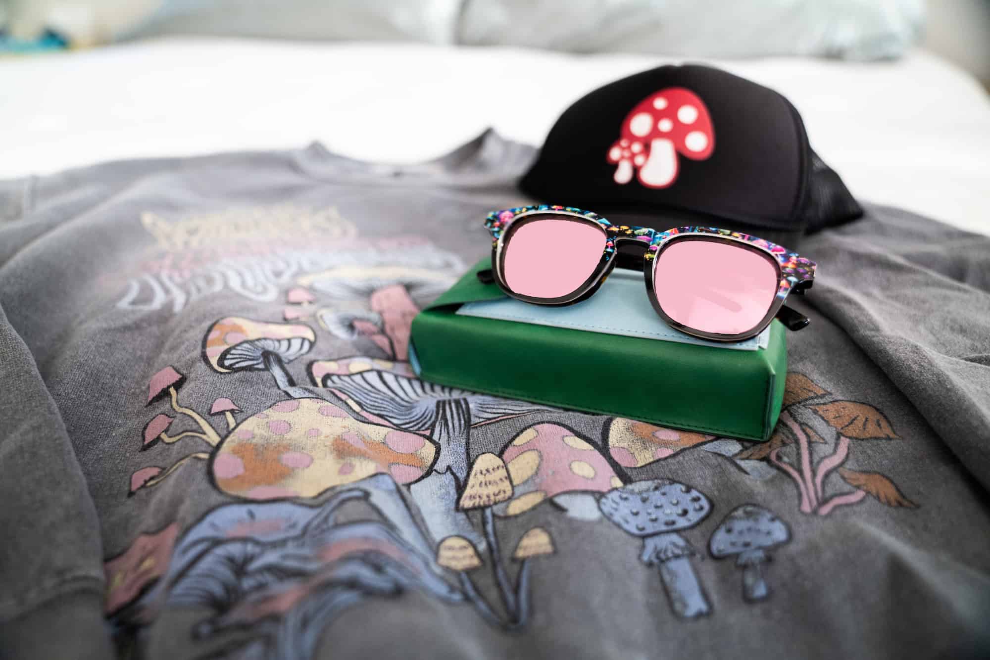Flat lay of a mushroom sweater, mushroom hat and sunglasses 