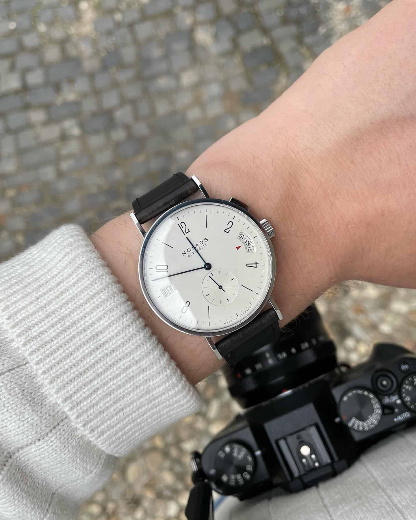a traveler wearing a Nomos Glashuette watch
