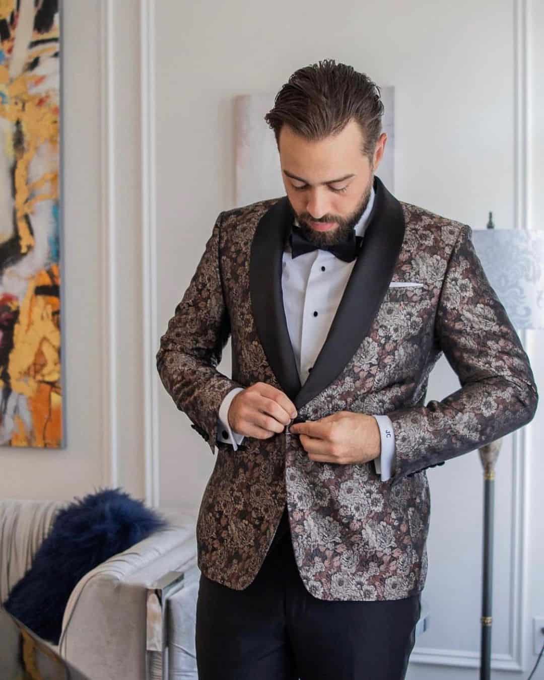 man buttons his suit jacket