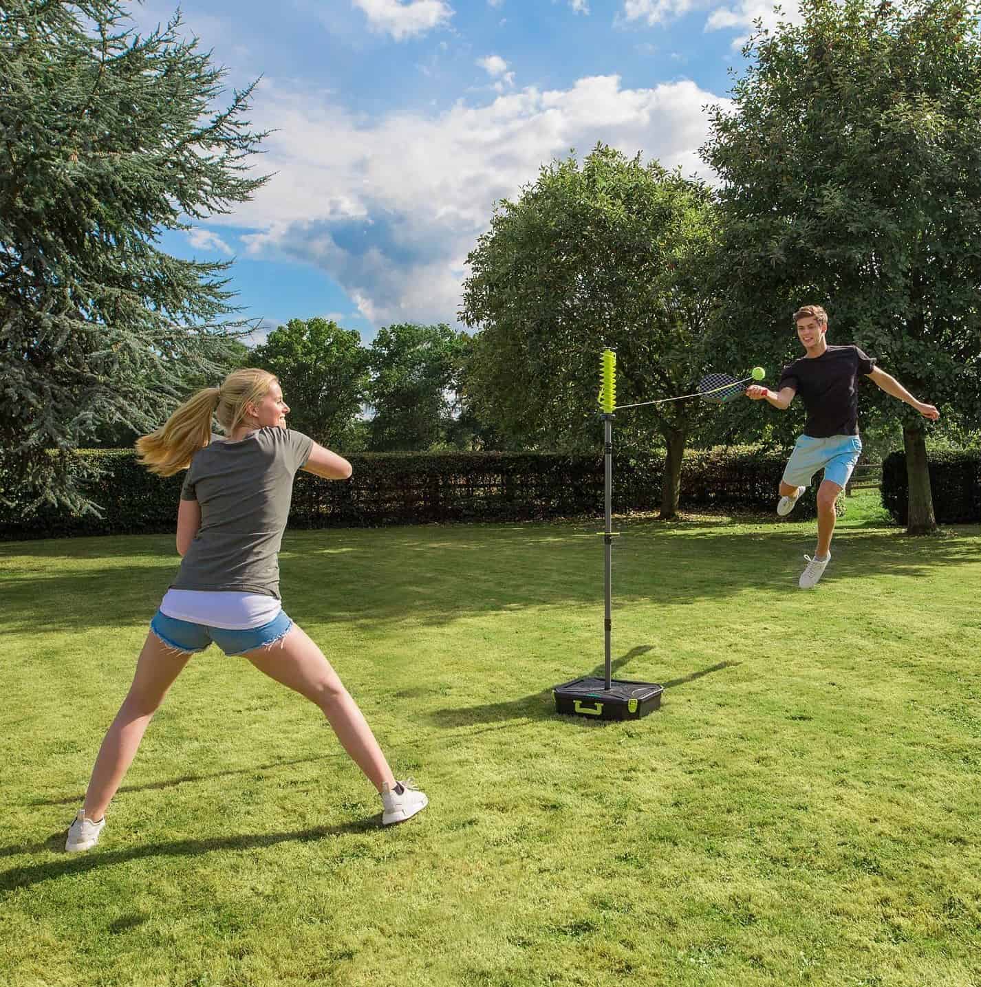 couple playing swingball at the backyard