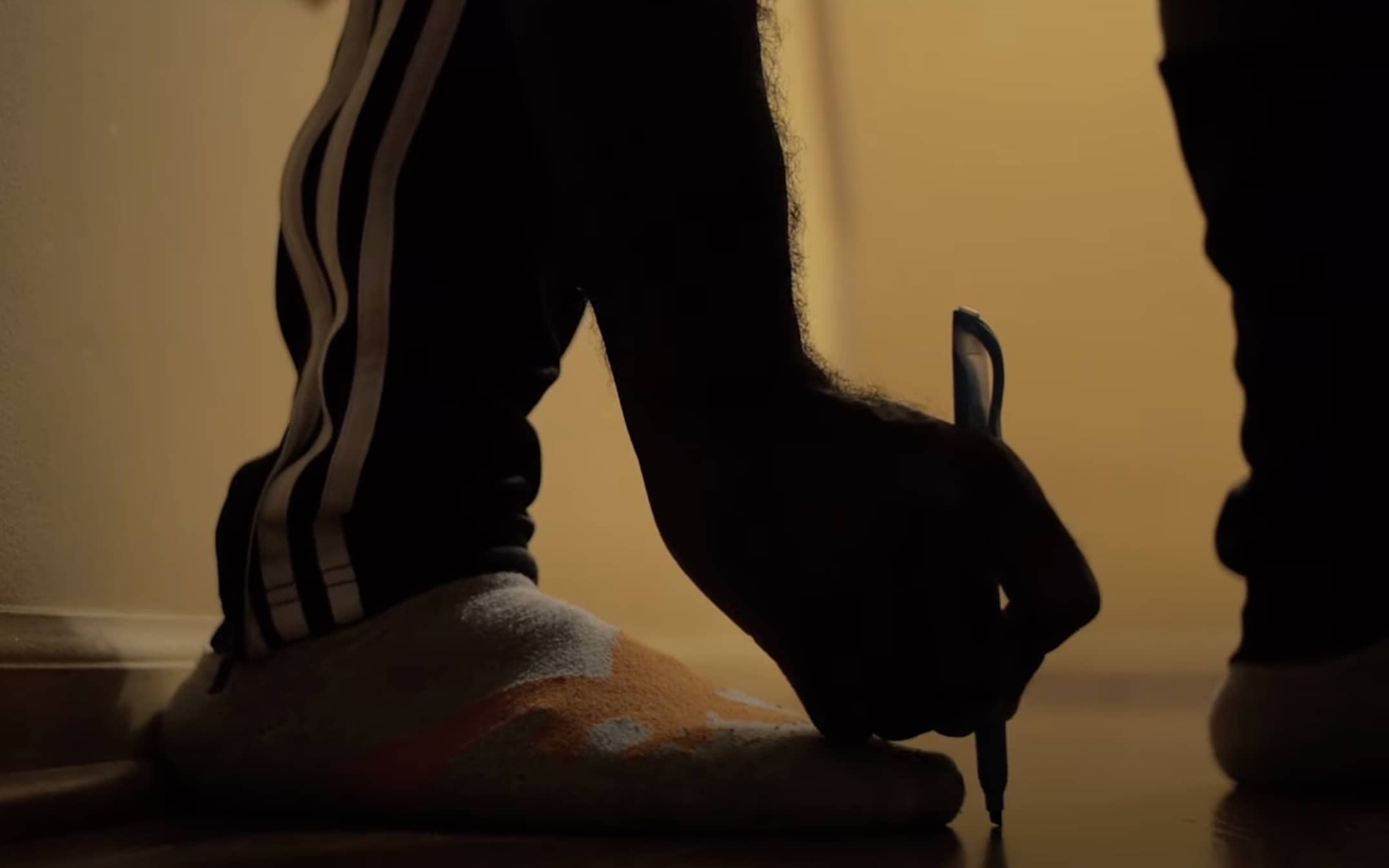 Person measuring their foot on the floor 