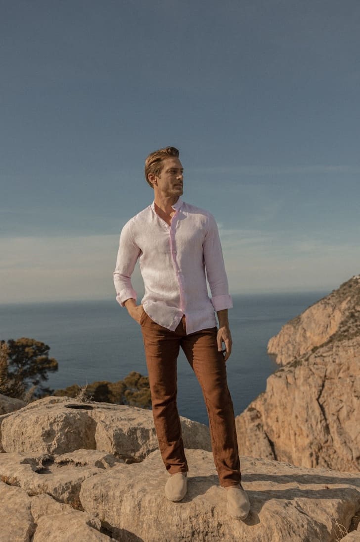 man standing on a cliff in Luca Faloni clothes 