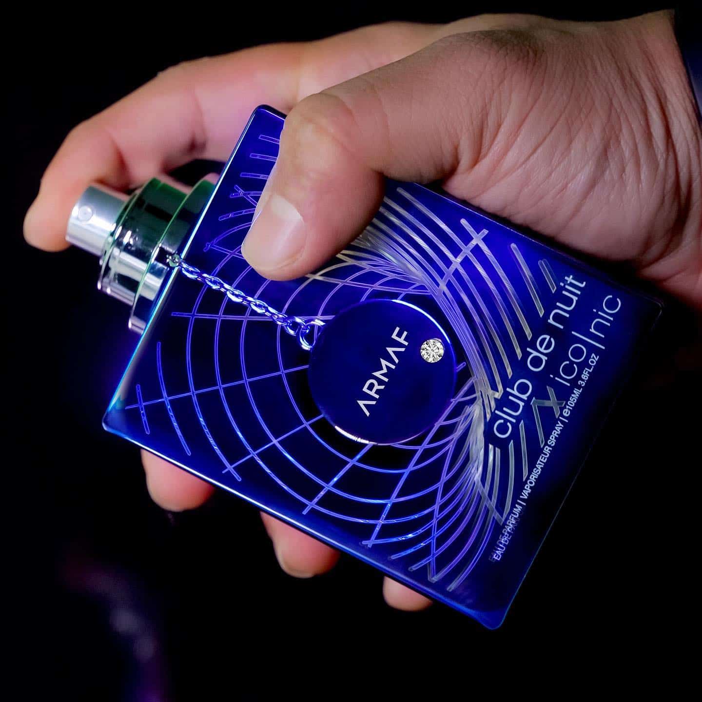 holding a bottle of club de nuit iconic by armaf