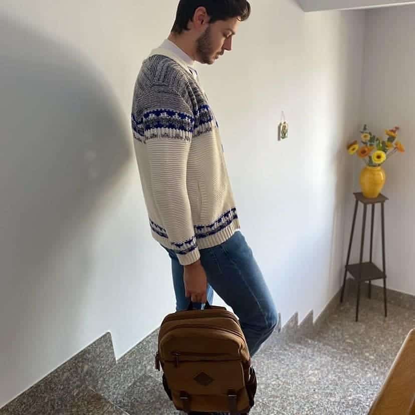 man going down the stairs carrying a backpack