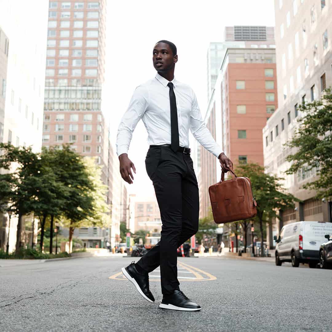 man in a shirt and tie crossing the street
