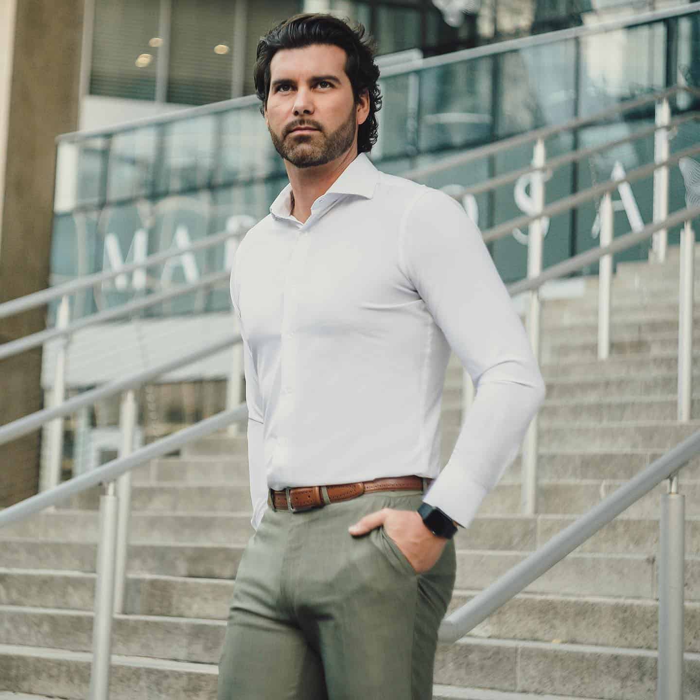 man in a slim fit shirt and khaki pants going down the stairs