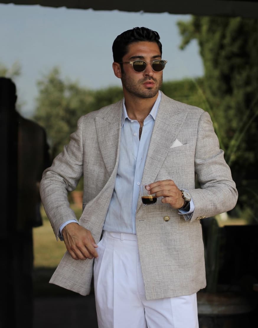 man wearing bespoke Hockerty linen suit holding espresso and wearing sunglasses