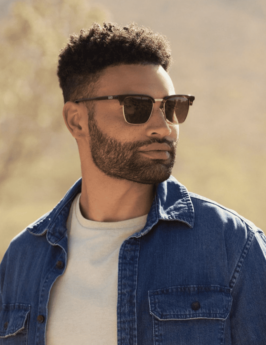 Man wearing sunglasses in the desert looking away from the camera