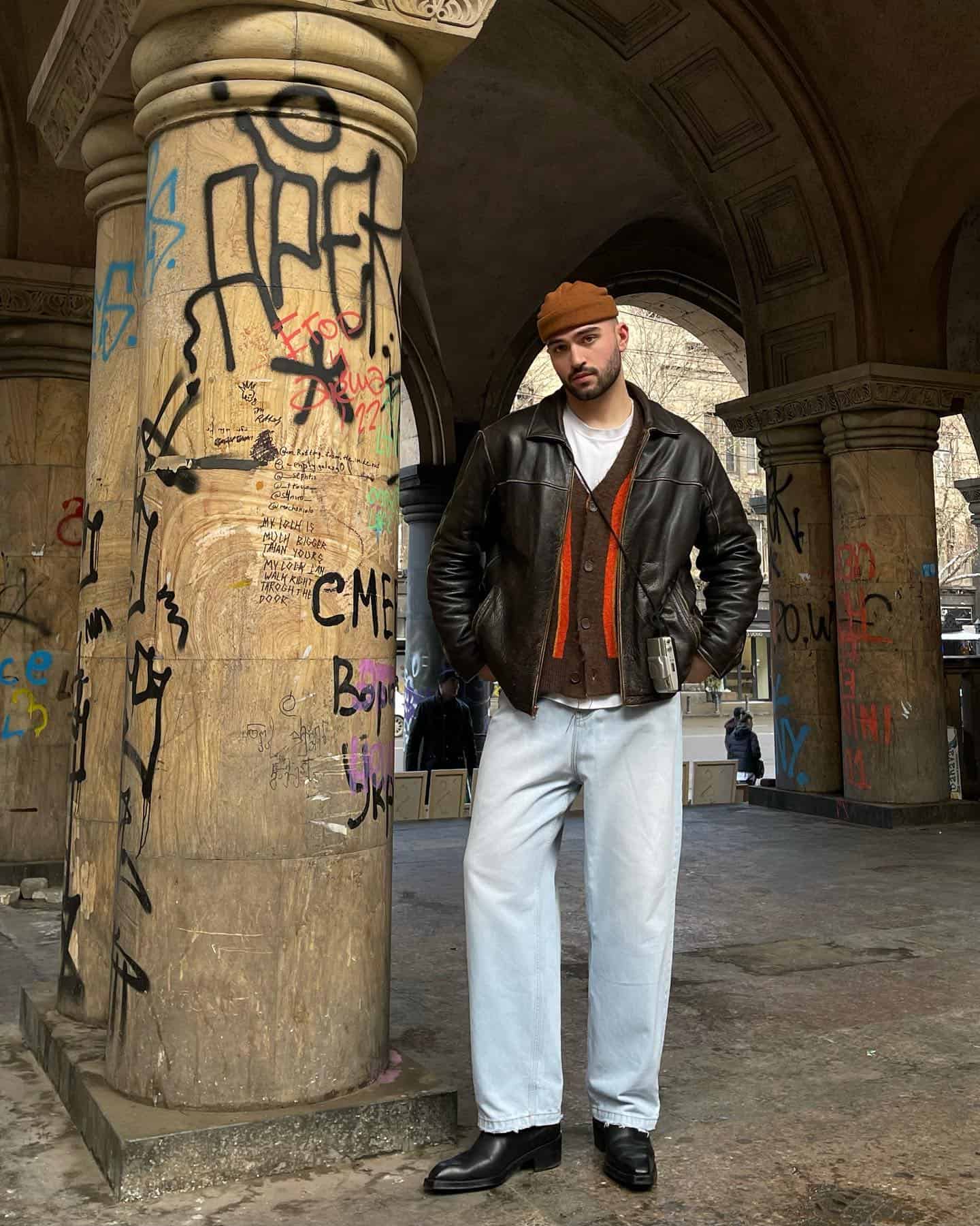 man standing beside vandalized pillars
