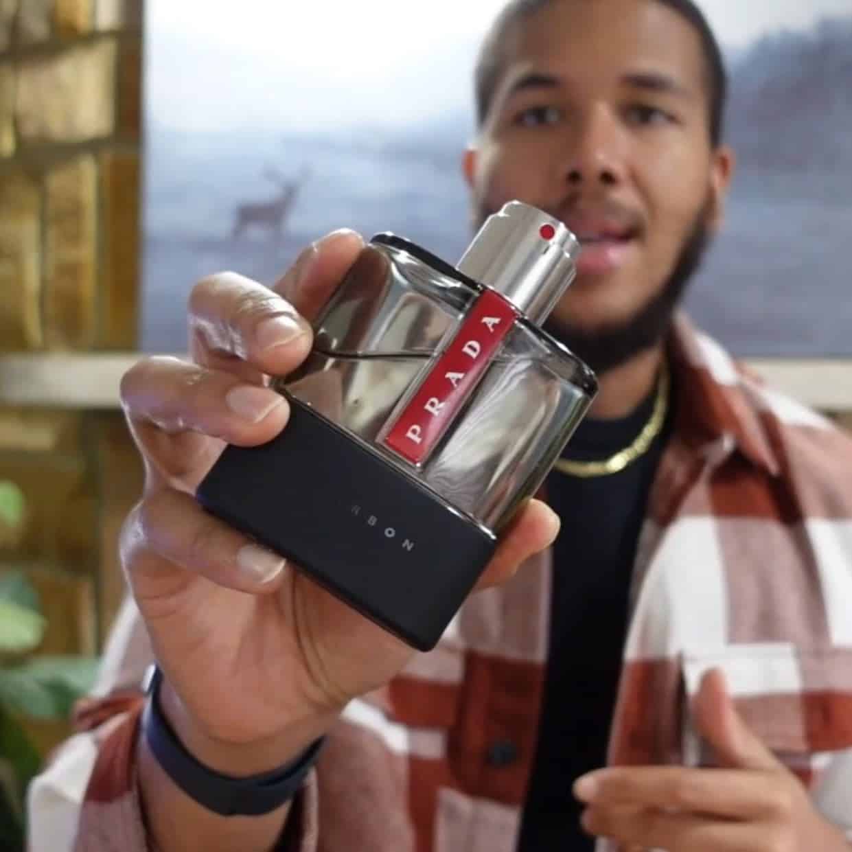 man holding a bottle of luna rossa carbon from prada