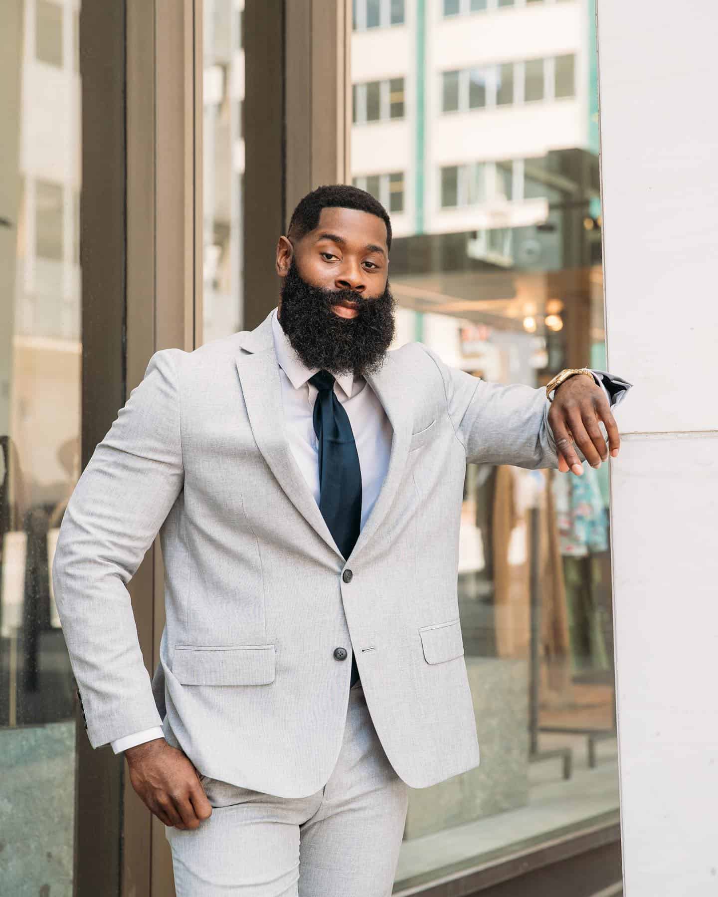 full bearded man in a light grey suit