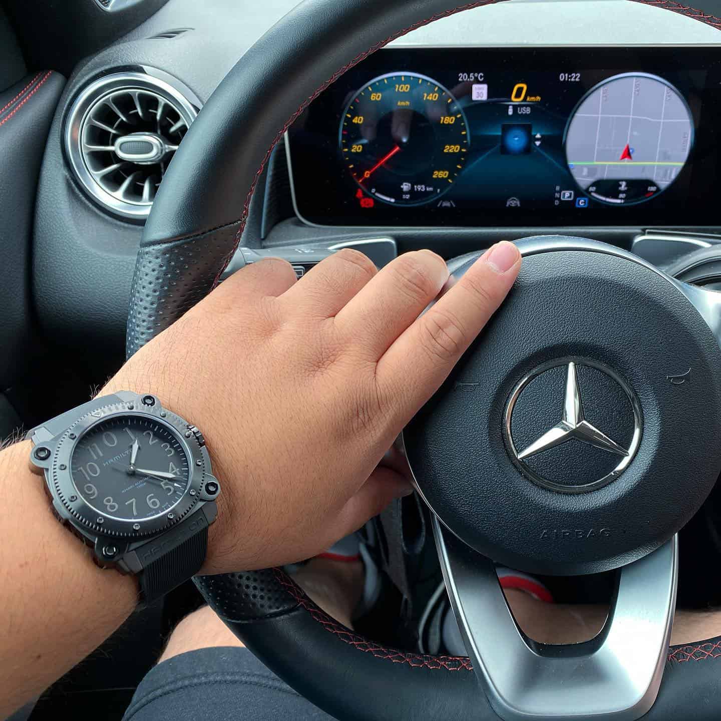 man driving a car wearing a hamilton belowzero watch