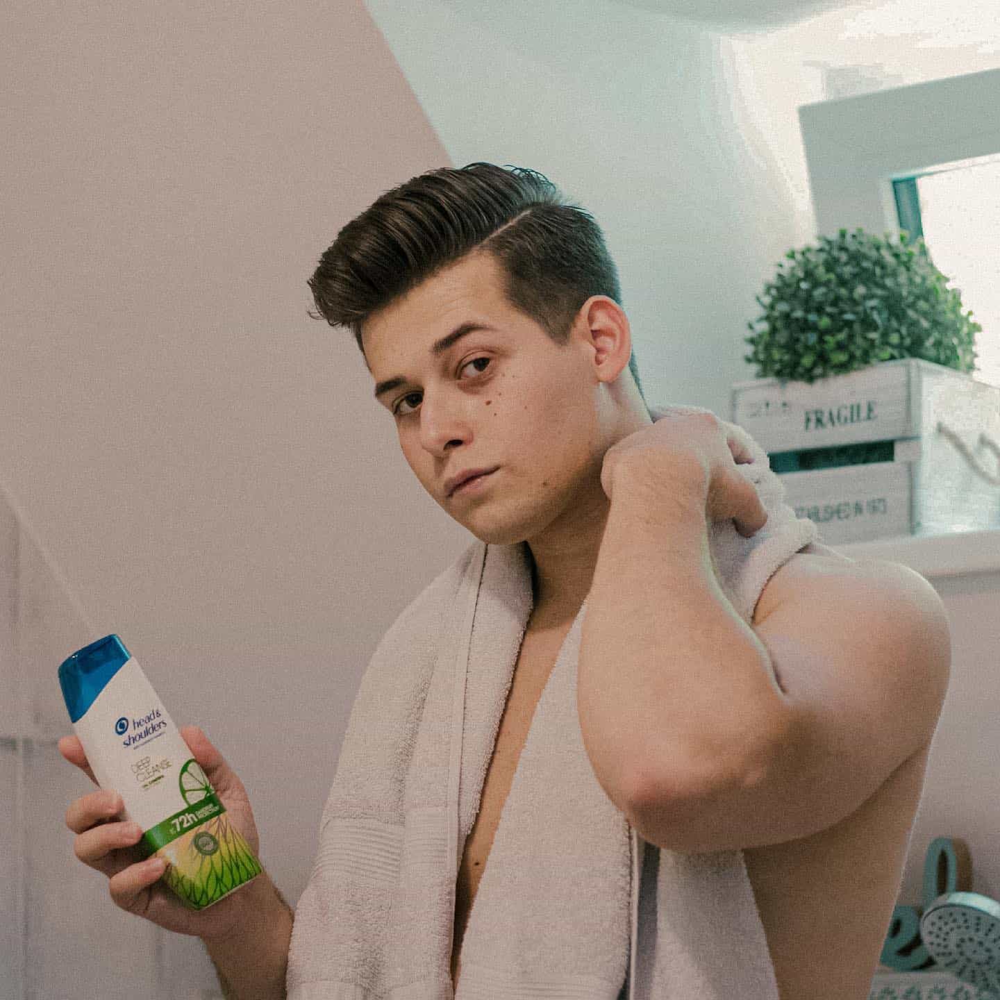 man holding a bottle of head and shoulders shampoo