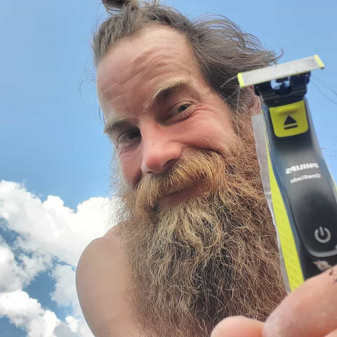 man with long beard holding a norelco oneblade