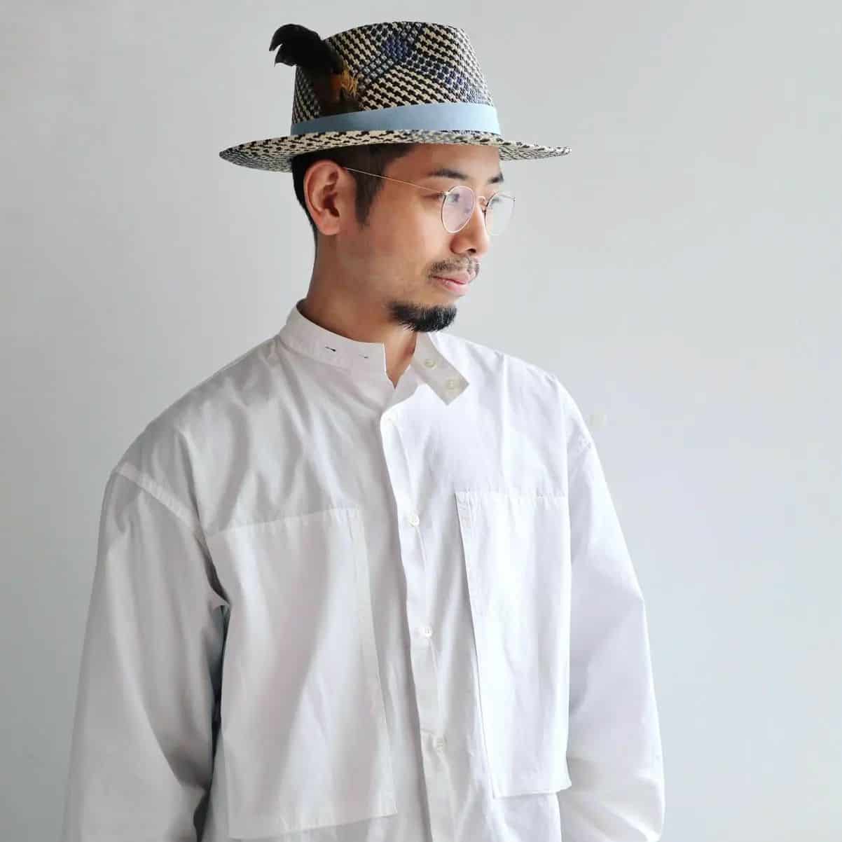 man wearing a straw hat with a feather