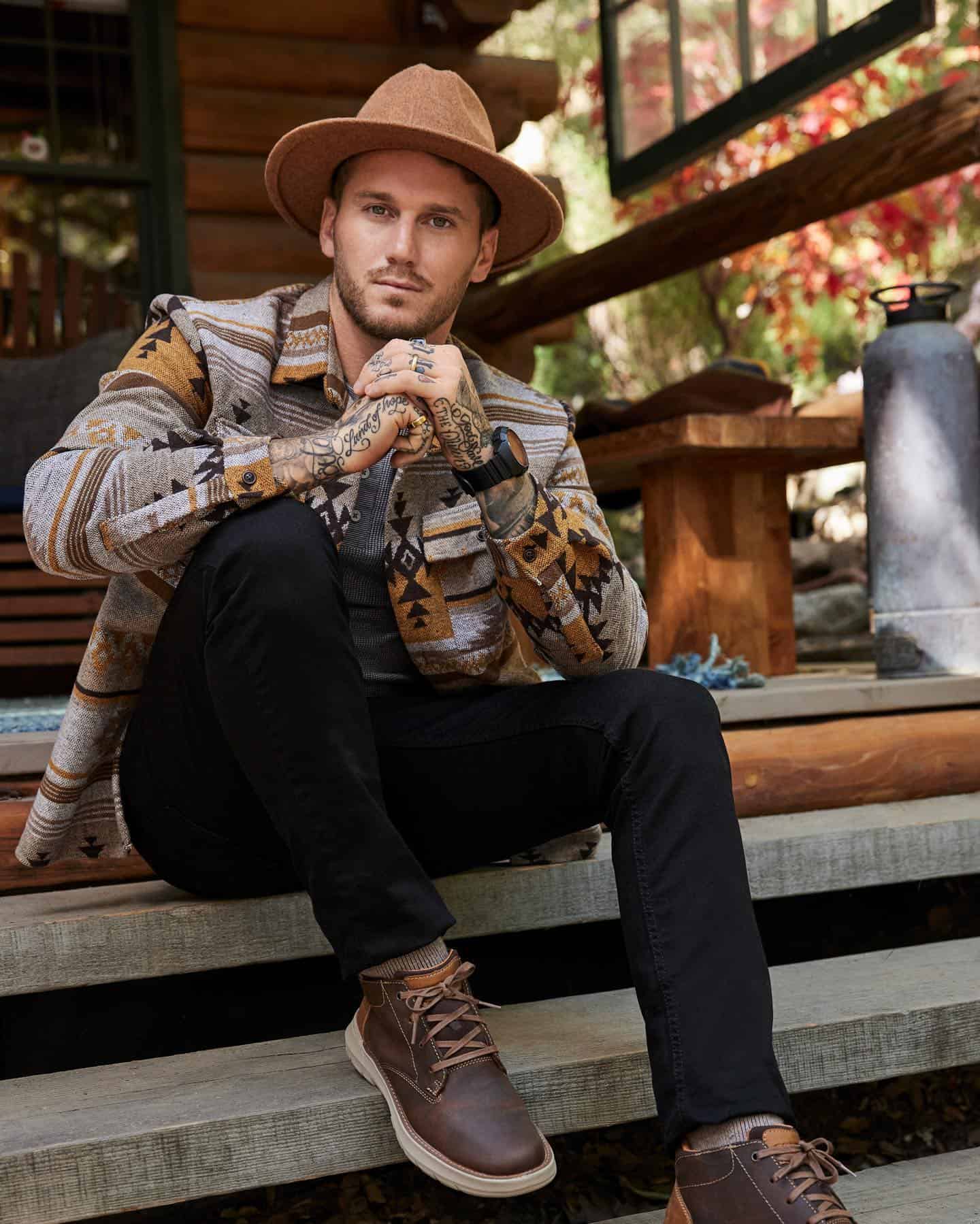 man in a cowboy hat sitting on a wooden stair