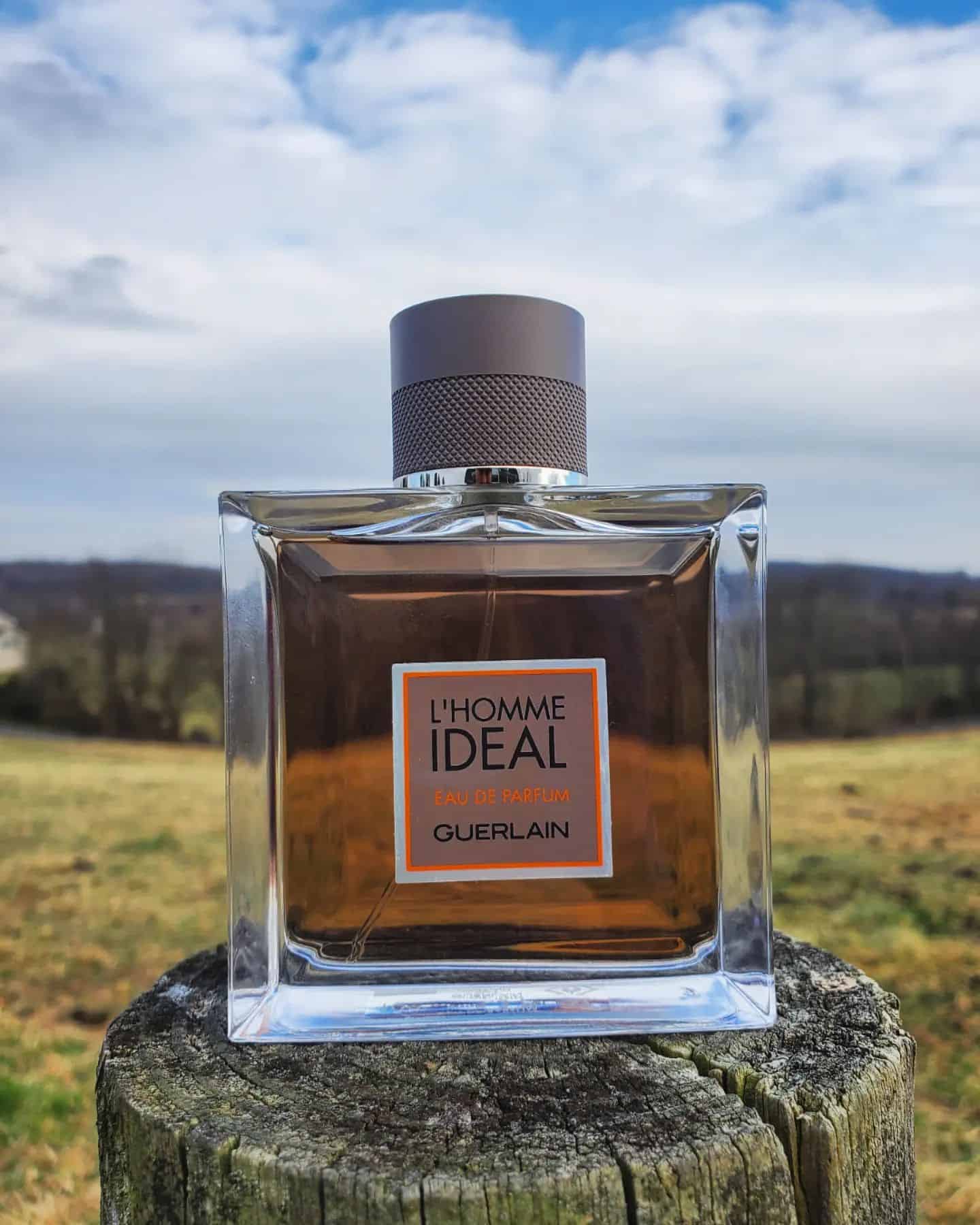 a bottle of Guerlain L'Homme Ideal on top of a wooden fence