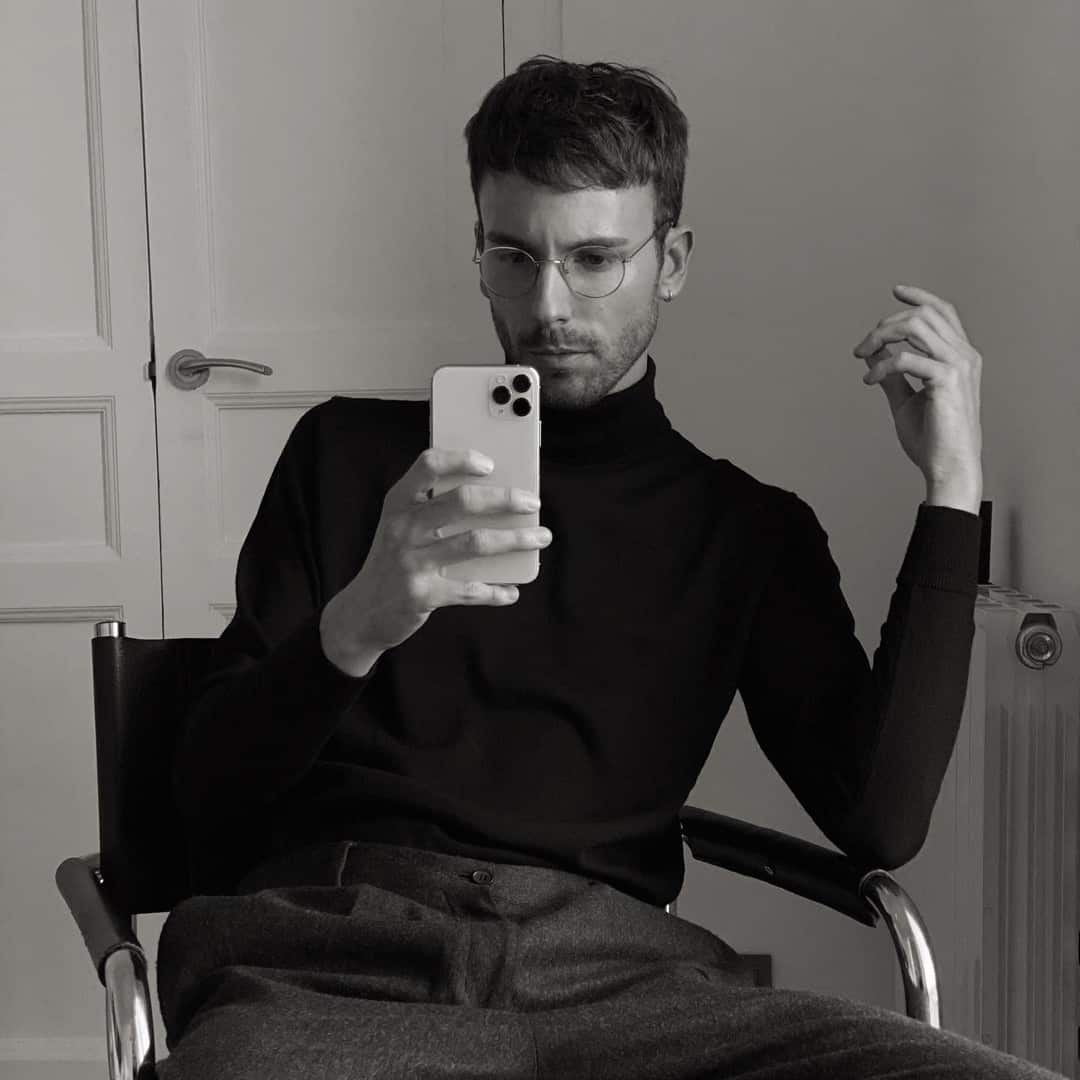 man sitting on a chair while holding his phone