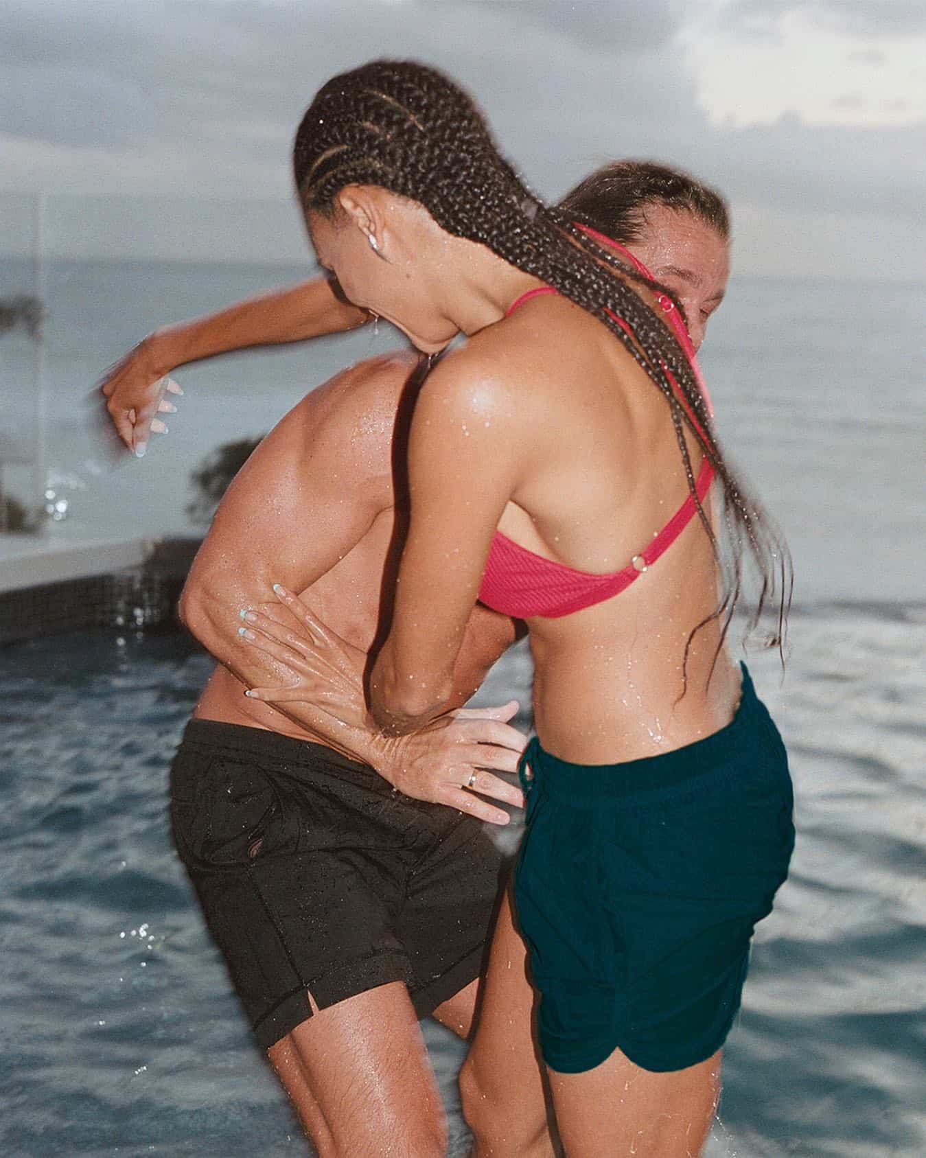 man and woman pushing each other by the beach