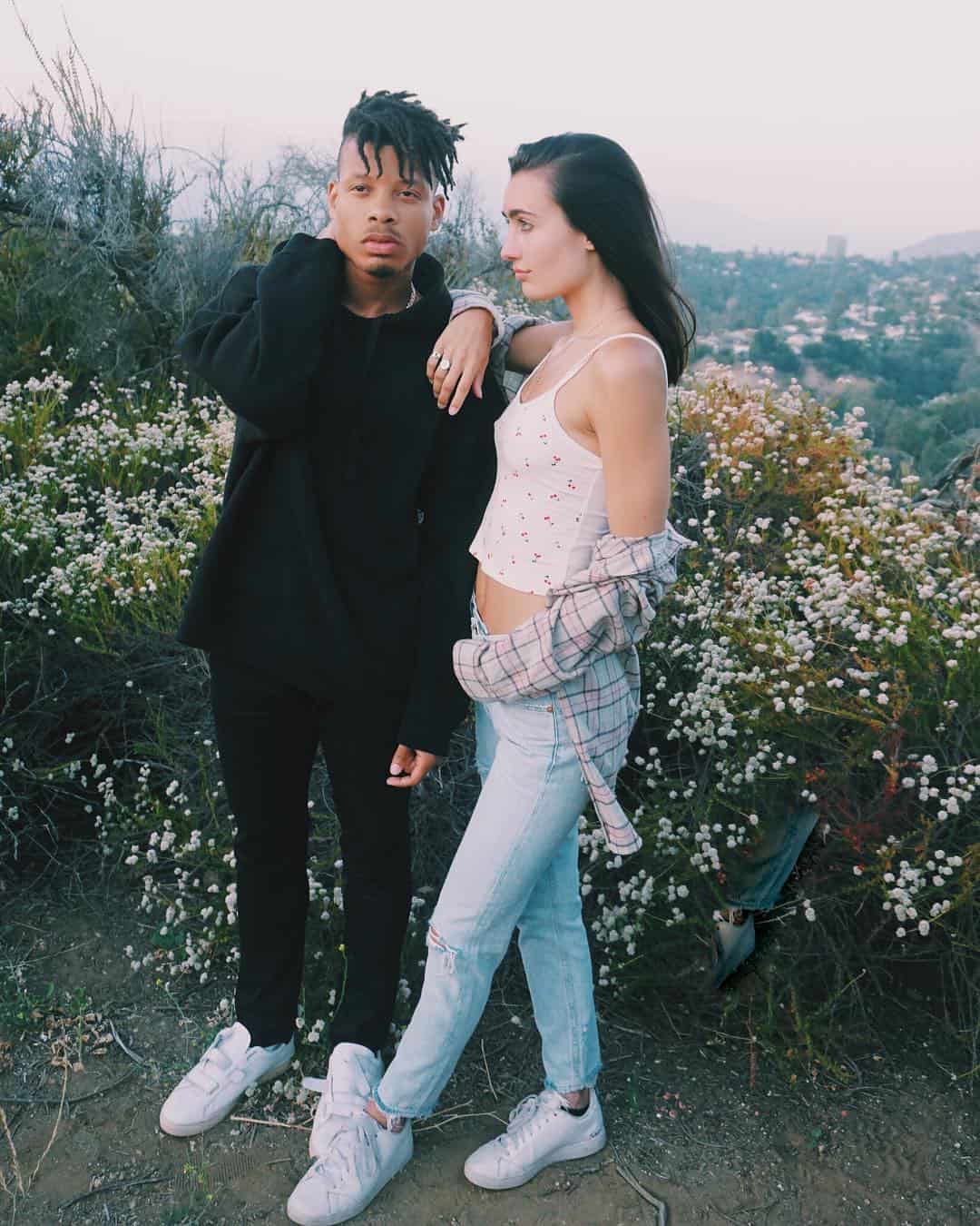 couple with white sneakers and flowers as background