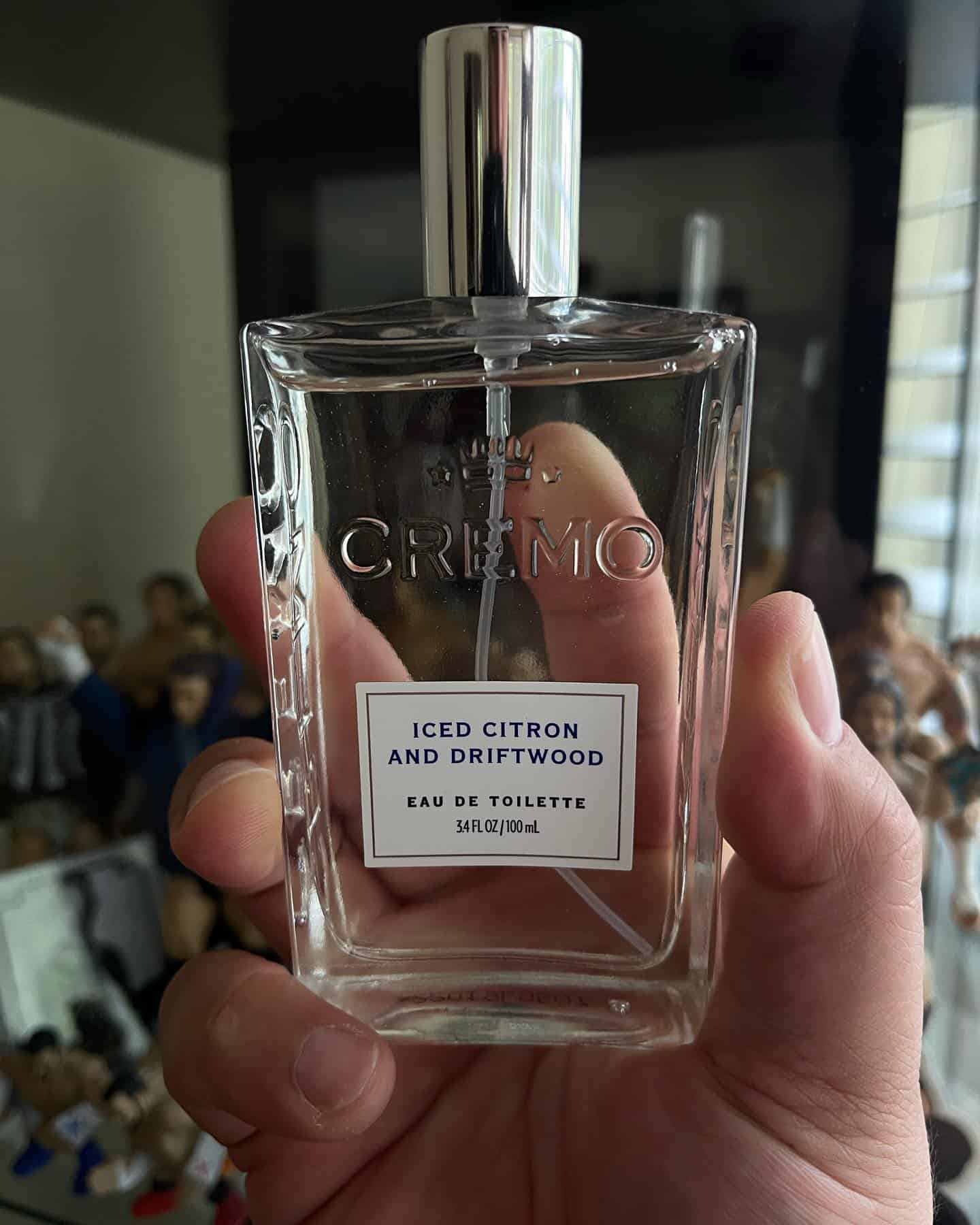 holding a bottle of iced citron and driftwood by cremo